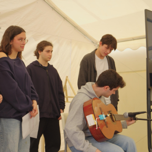 Students show the guitar implement they designed
